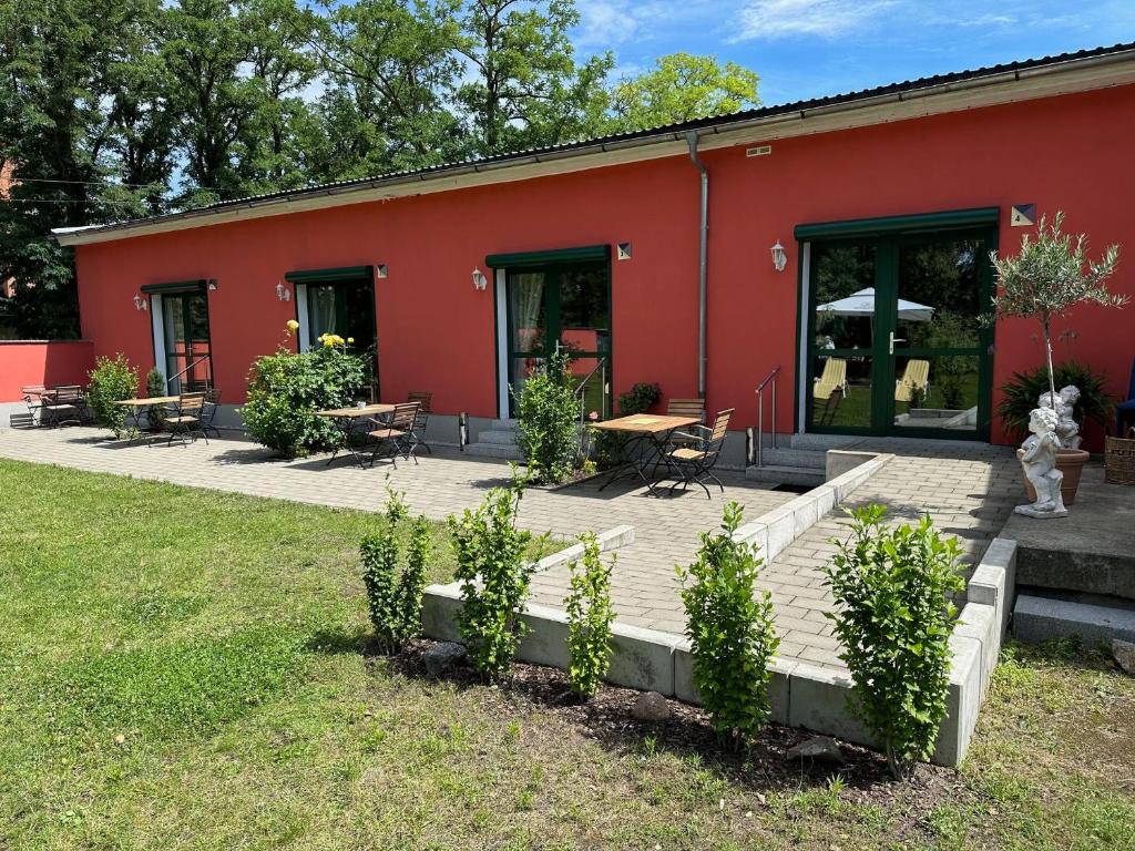 a red building with a picnic table and benches at Bed & Breakfast am Waldgürtel in Forst