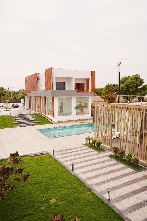 a house with a swimming pool in front of it at Sandy Resort in Agastīswaram