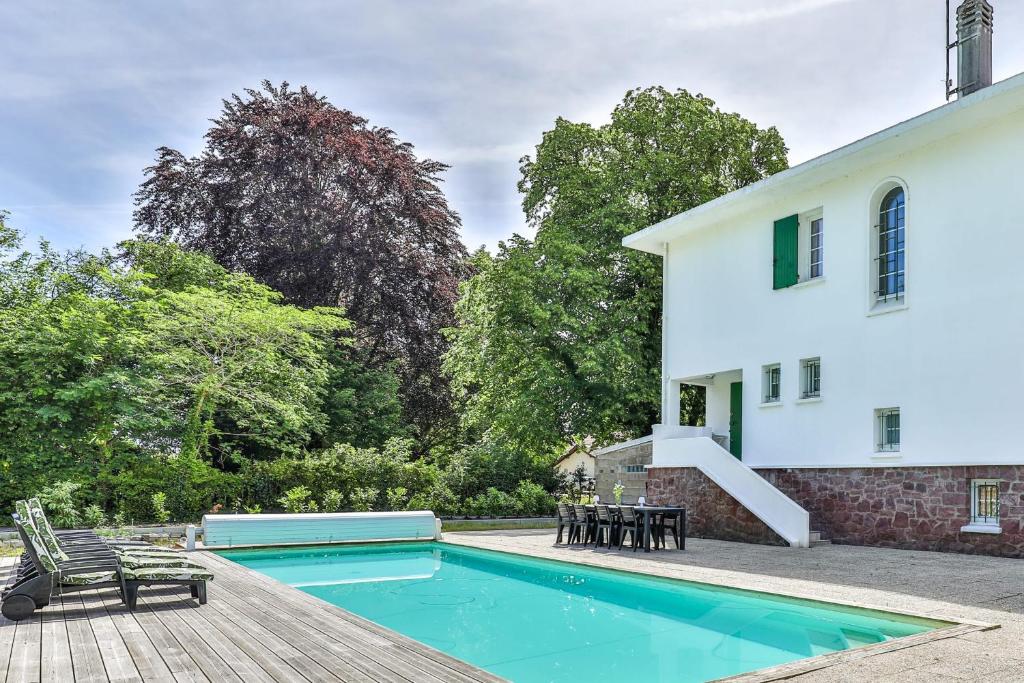 a swimming pool in front of a house at Lavignottes - AC - Piscine & Tennis in Labouheyre