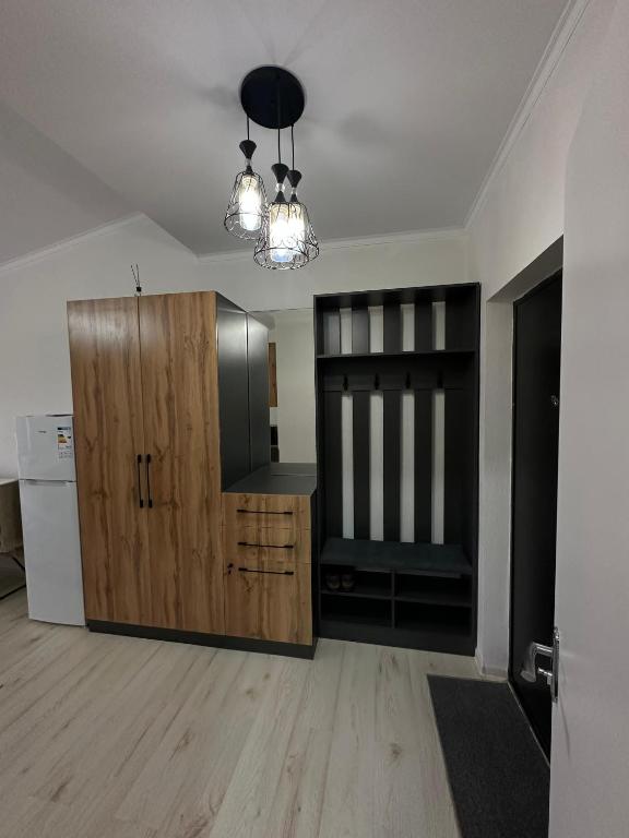 a kitchen with a wooden cabinet and a refrigerator at RADUGA West in Koshkolʼ