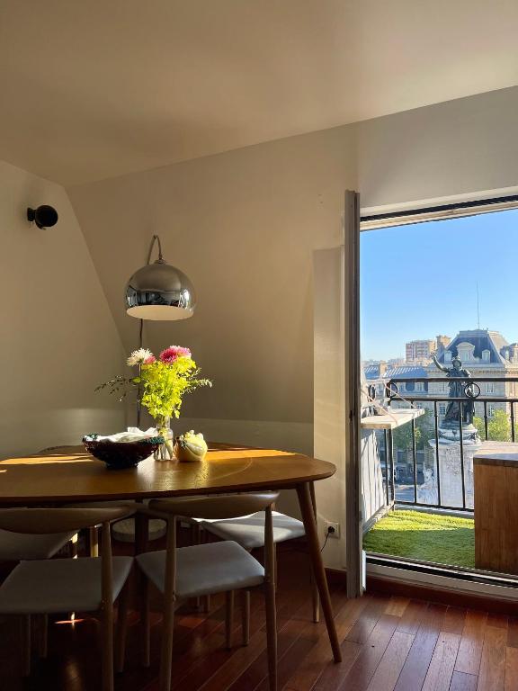 a dining room with a table and a large window at Eiffel Tower View Apartment in Paris