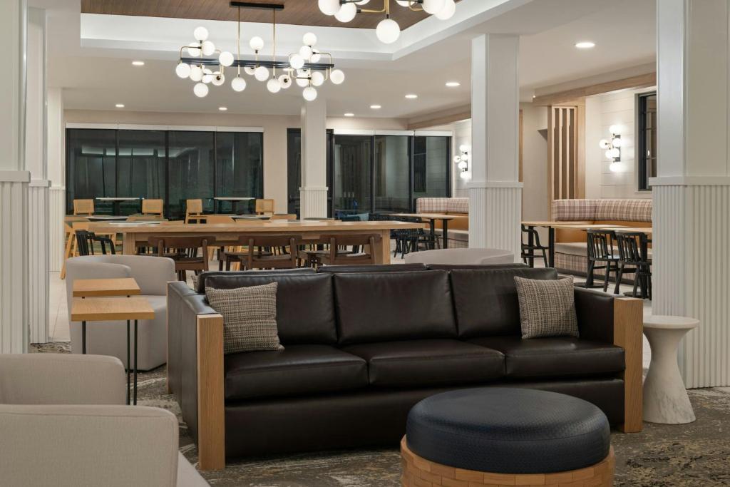 a living room with a black couch and tables at TownePlace Suites by Marriott Corbin in Corbin