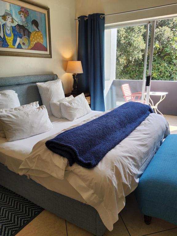 a bedroom with a bed with a blue blanket on it at Bentley on the Beach in Umhlanga