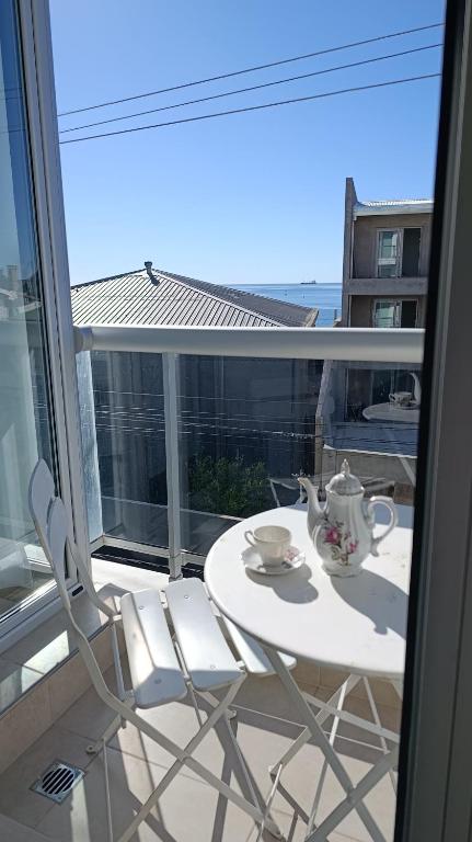 a table and chairs on a balcony with a tea set at Del Santo San Rafael in Puerto Madryn