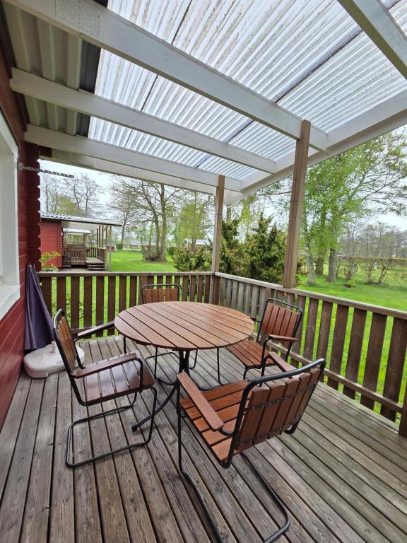 a patio with a table and chairs on a deck at Sonjas Camping & Stugor in Löttorp