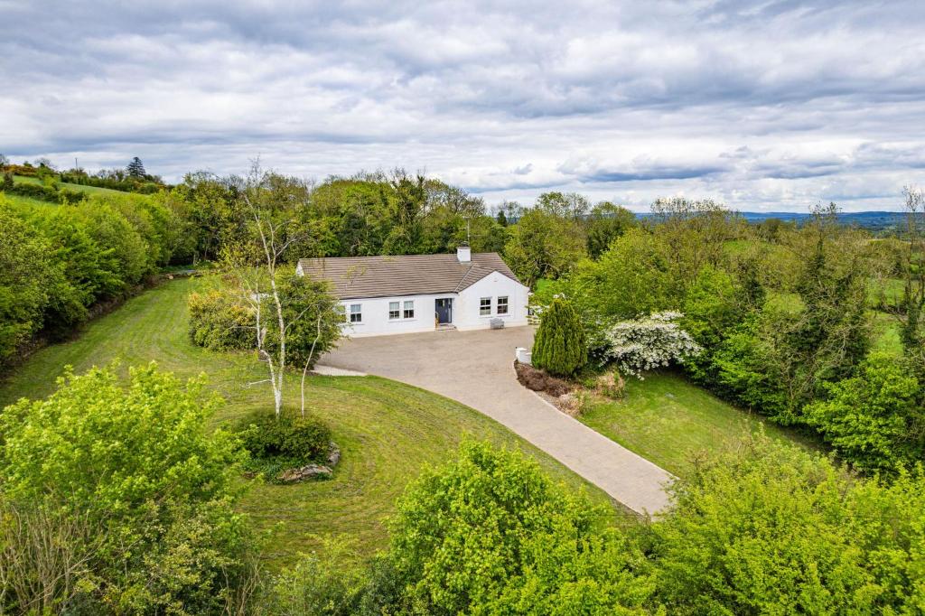 an aerial view of a white house with a driveway at Hilltop Views by Escape Ordinary in Killyhevlin