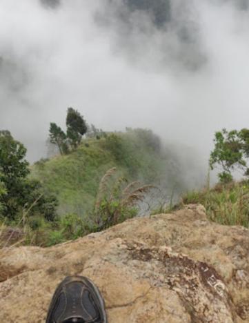 a person standing on top of a rock at Secret Garden Ella Cabana & Stay in Ella