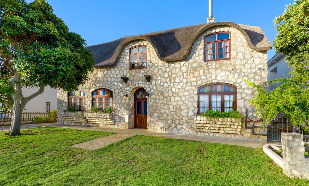 an old stone house with a roof at Arniston Hotel Manor House in Arniston