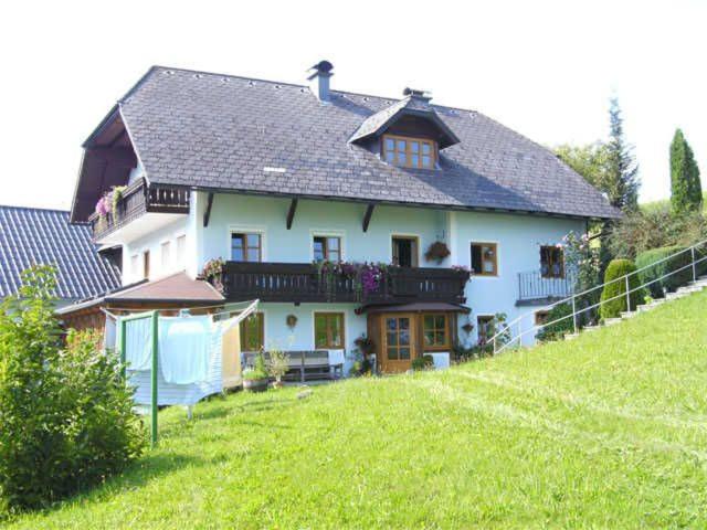 ein großes weißes Haus mit Balkon auf einem Hügel in der Unterkunft Minabauer in Altmünster