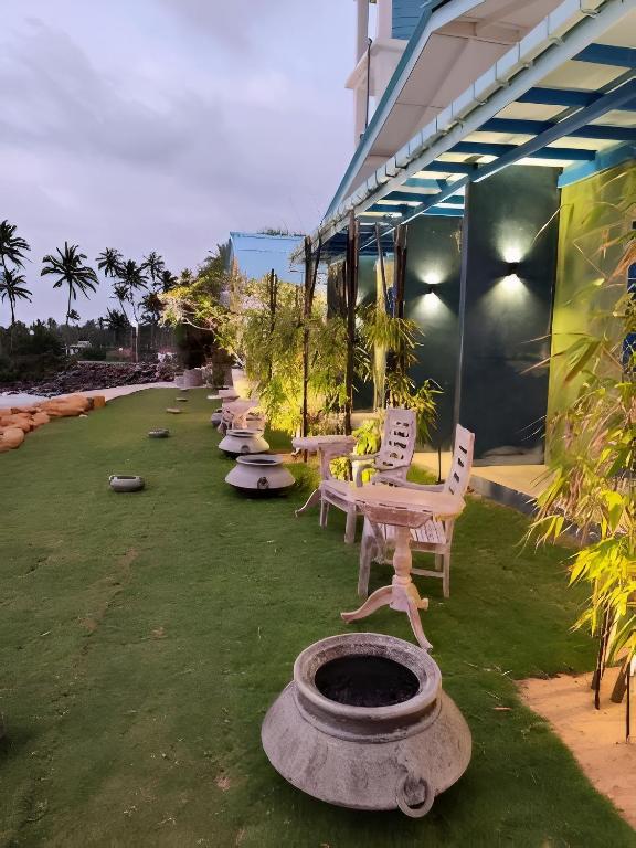 a row of chairs and tables on a lawn at Refuge Boutique Villa in Hikkaduwa