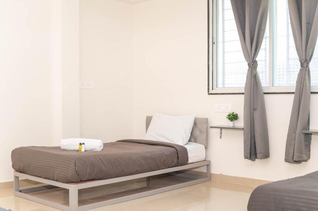a bed sitting in a room with a window at Z Express Zen Elite in Pune