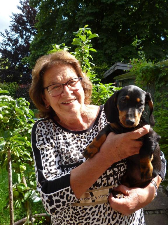 a woman holding a dog in her arms at Haus St_ Michael_ Ferienwohnung 1_4 in Schliersee
