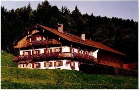 ein Haus mit Blumen an einem Hang in der Unterkunft Bocksleitnerhof in Wackersberg