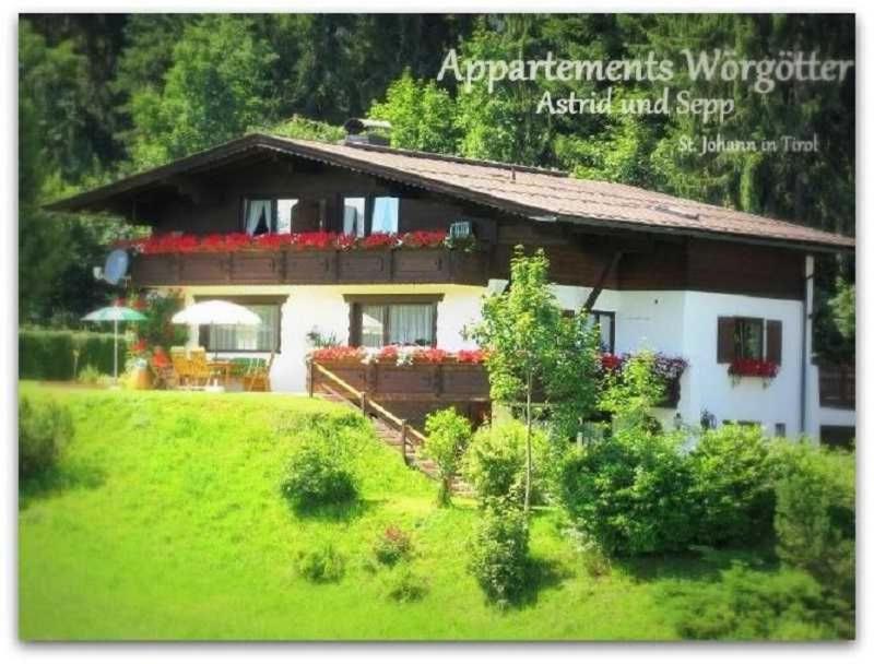 a house on a hill with a green yard at Appartements Wörgötter Astrid & Sepp in Rettenbach