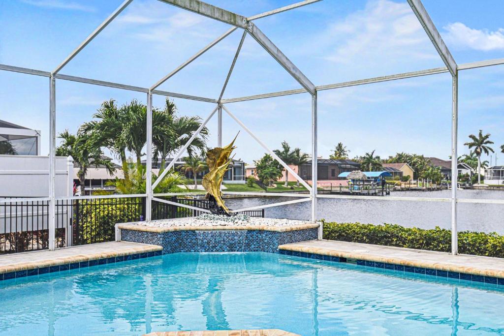 a swimming pool with a fountain in the middle at Sunsets At Tiki Terrace in Cape Coral
