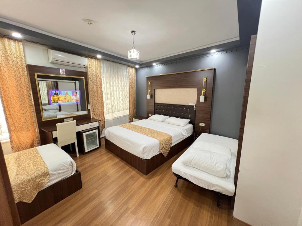 a hotel room with two beds and a television at Karakoçan Hotel Hanedan in Karakoçan