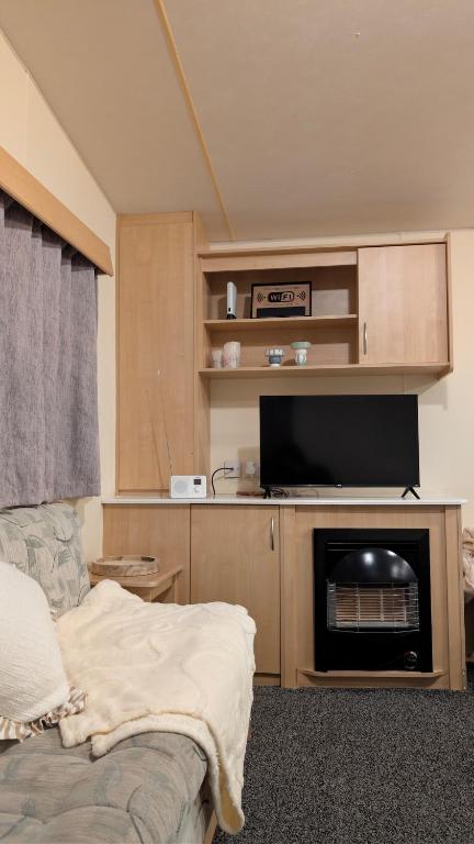 a living room with a couch and a flat screen tv at Shore&Meadow Holiday Lets - Luxury 8 berth caravan at Regent Bay in Morecambe