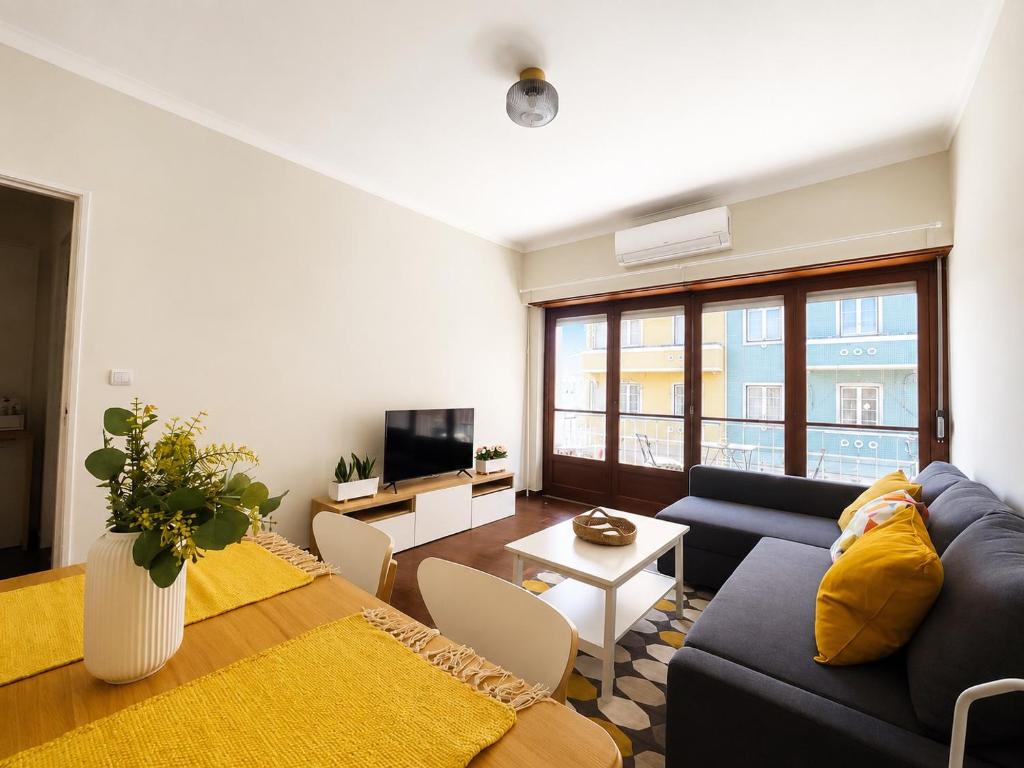 a living room with a couch and a table at Lx Factory Apartment-Lisbon Style-Spacious & Bright-Congress Centre in Lisbon