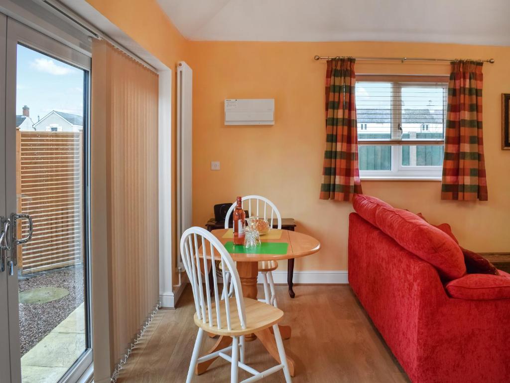 a living room with a red couch and a table at The Squirrels in Great Malvern