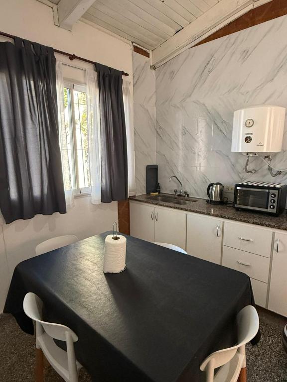 a kitchen with a black table with two chairs at Casa YRIGOYEN in Junín