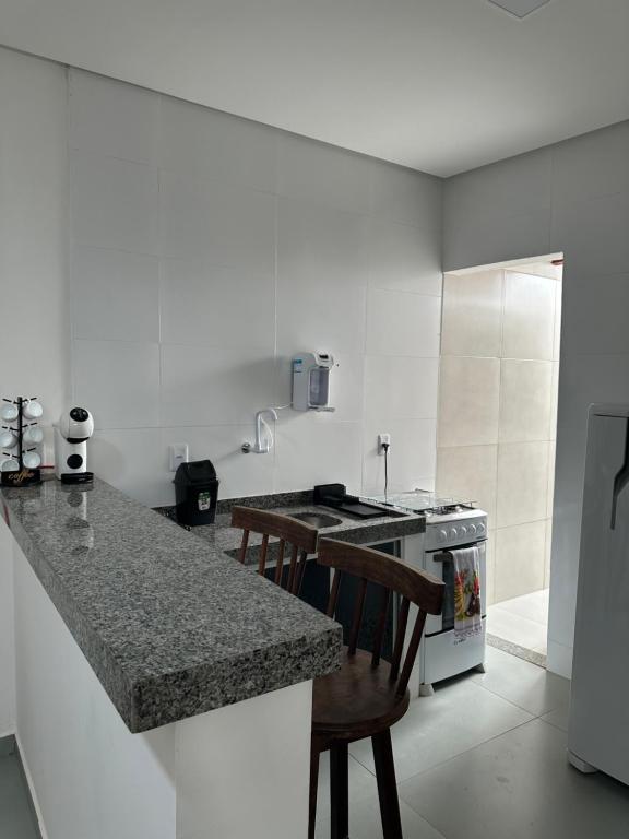 a kitchen with a counter and a stove top oven at Apartamento aconchegante em Irecê in Irecê