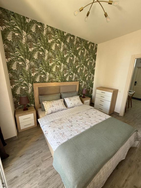 a bedroom with a large bed and a wall mural at Cozy place New Boulevard in Batumi