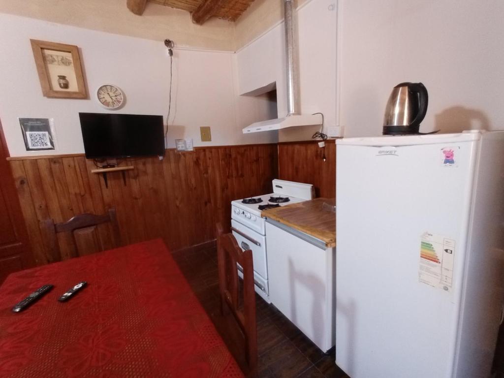 a kitchen with a white refrigerator and a table at K&M descanso y excursiones in Fiambalá
