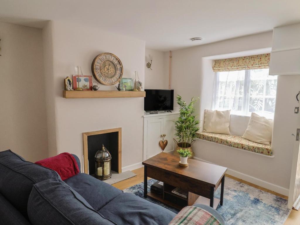 a living room with a couch and a fireplace at 6 Bedford Place in Bridport