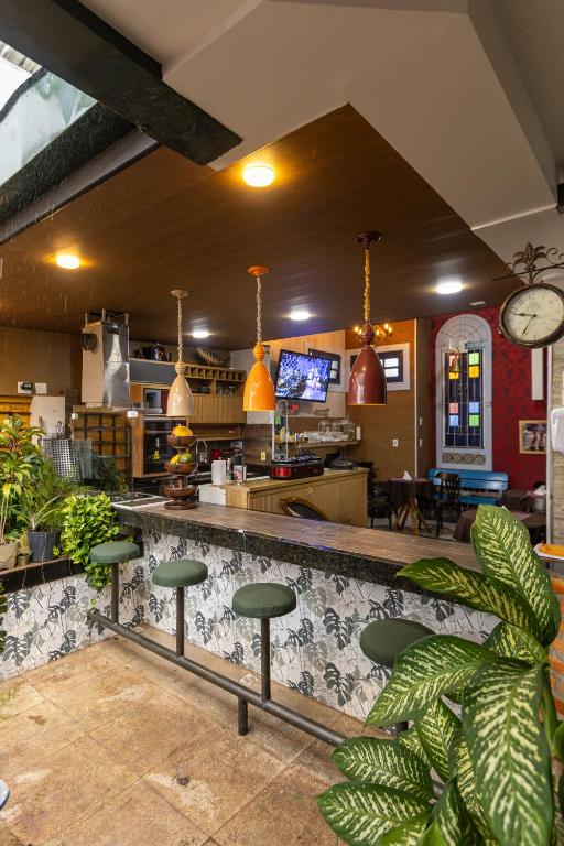 a restaurant with a bar with green stools at Studio Bangalô Belém Hospedagem in Belém