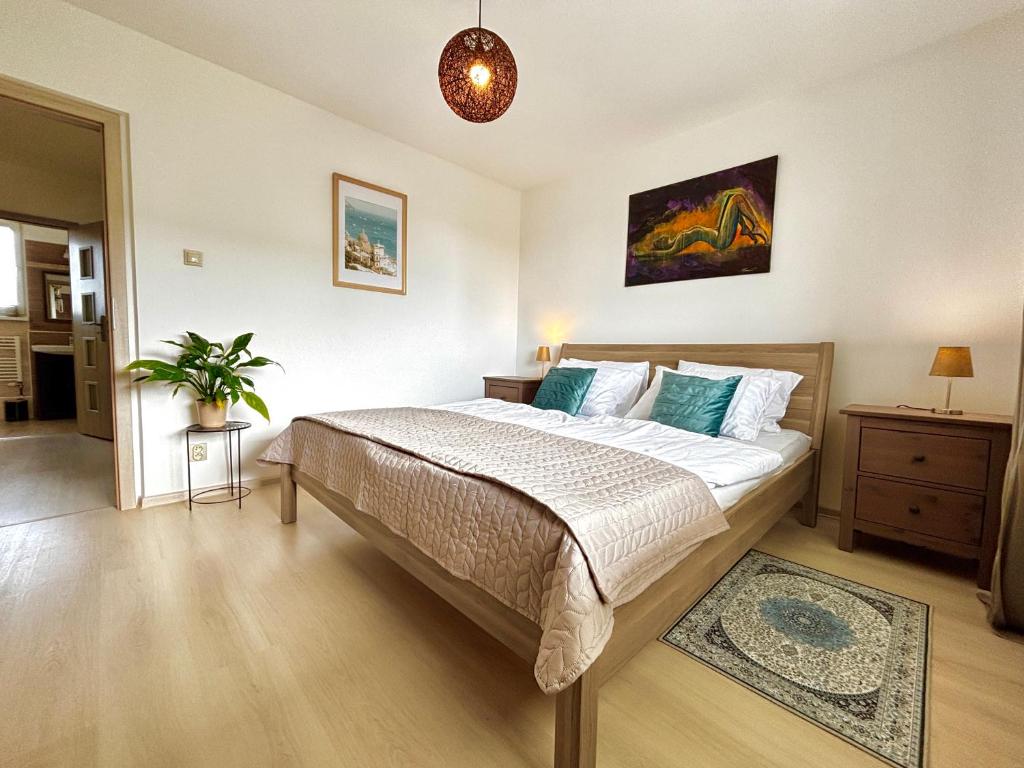 a bedroom with a bed and a potted plant at Samaria Central Apartment in Šamorín