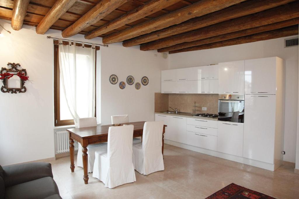 ヴェローナにあるCentre 2 bedroom Flatのキッチン(木製テーブル、白いキャビネット付)