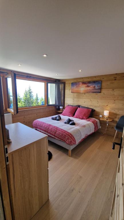 a bedroom with a bed with red pillows on it at Appartement Les Montagnes de Saxel in Saxel