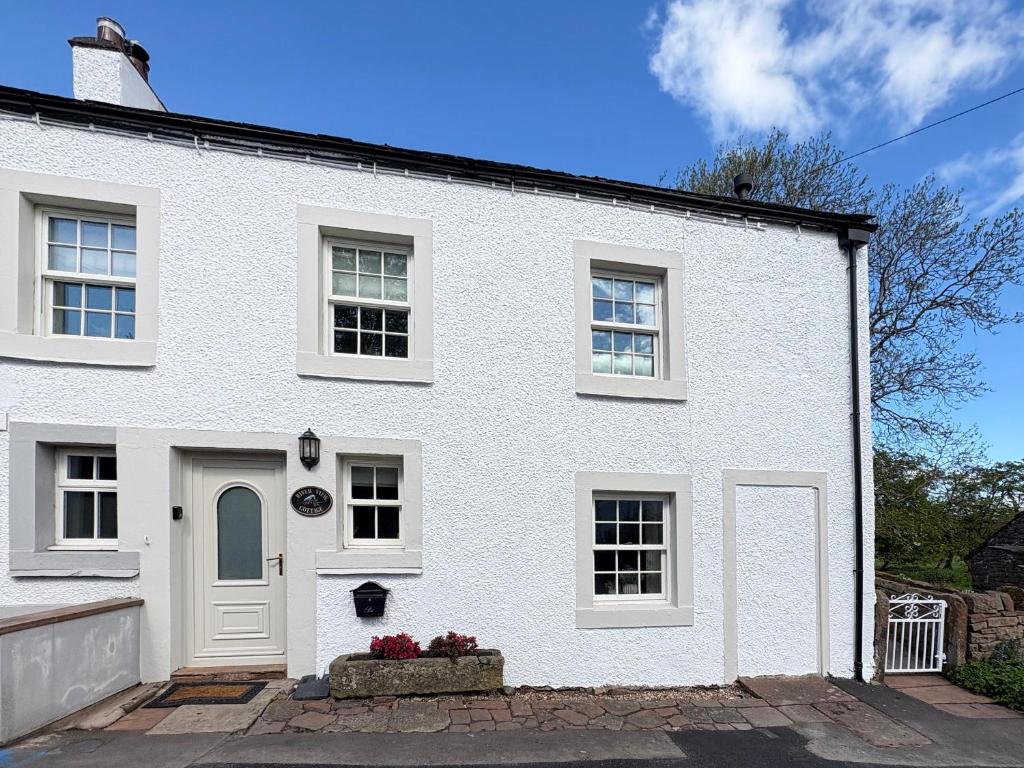 a white house with a white door and windows at River View in Lazonby