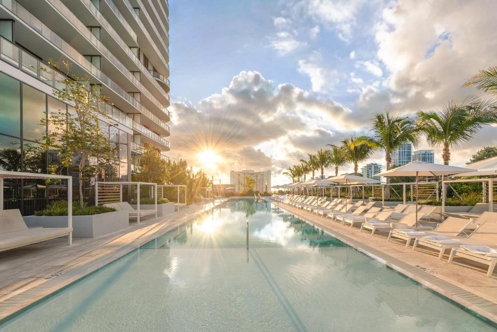a swimming pool with lounge chairs and a building at 72 Park by Nomada Residences in Miami Beach