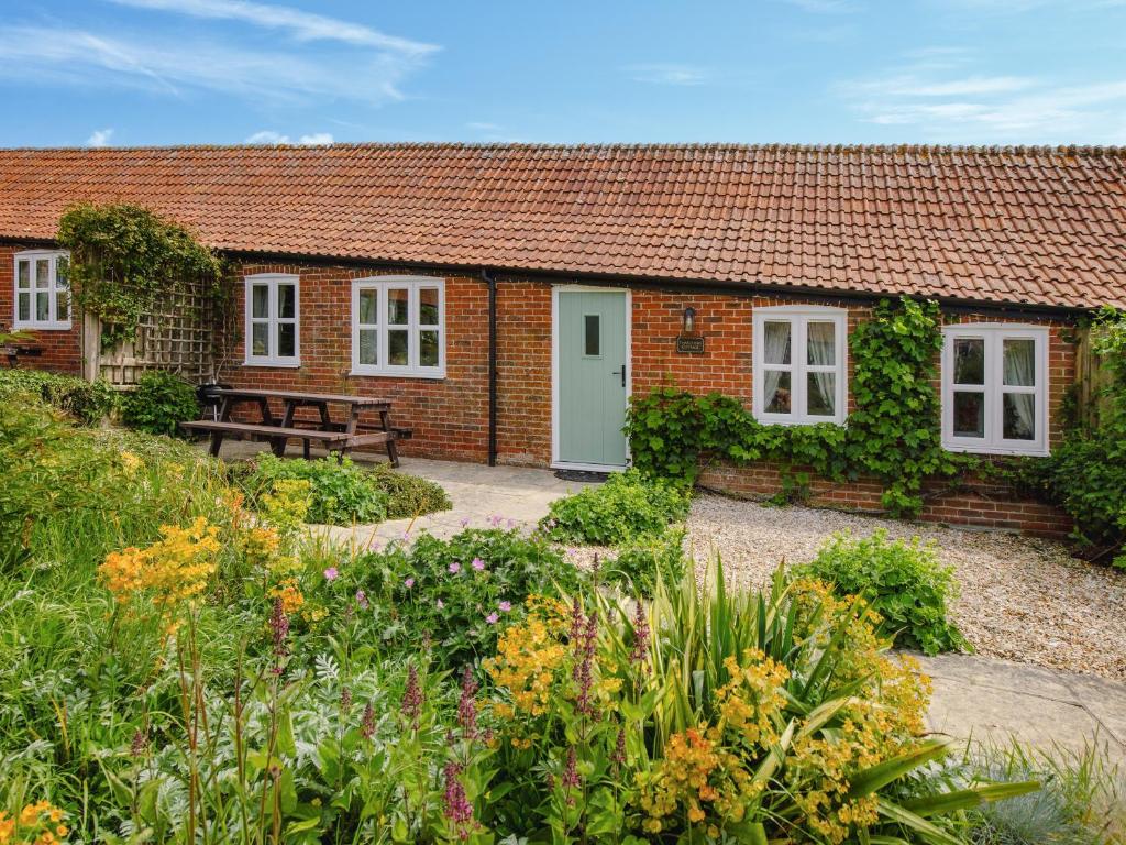a brick cottage with a bench in front of it at Thatcher's Cottage - Ukc3956 in Puncknowle