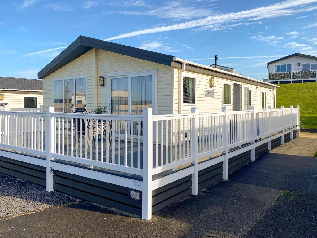 a mobile home with a white fence at Sunset Lodge in Lancaster