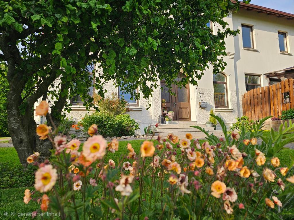 a garden with flowers in front of a house at Ferienhof Dahl in Wurster Nordseeküste