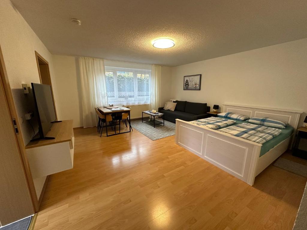 a living room with a bed and a couch at Ferienwohnung Kraus 2-4 Pers in Herbolzheim
