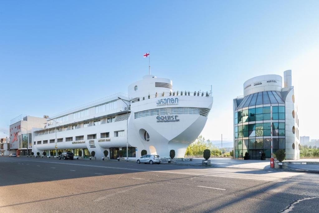 a large cruise ship parked next to a building at Cruise Hotel in Tbilisi City