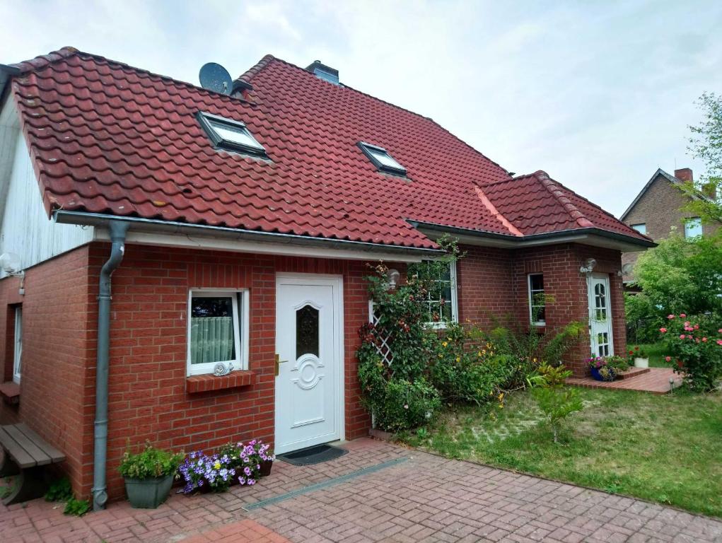 a red brick house with a white door at Ferienwohnung Zum Seeblick in Dahmen