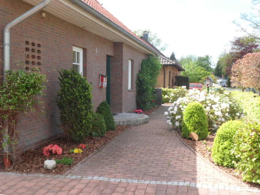 a brick house with a brick walkway and flowers at Ferienwohnung_Beethovenstrasse in Westerstede