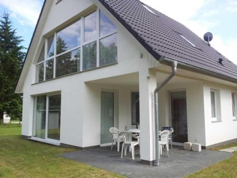 a house with a table and chairs in front of it at Ferienhaus Stang in Godendorfer Teerofen