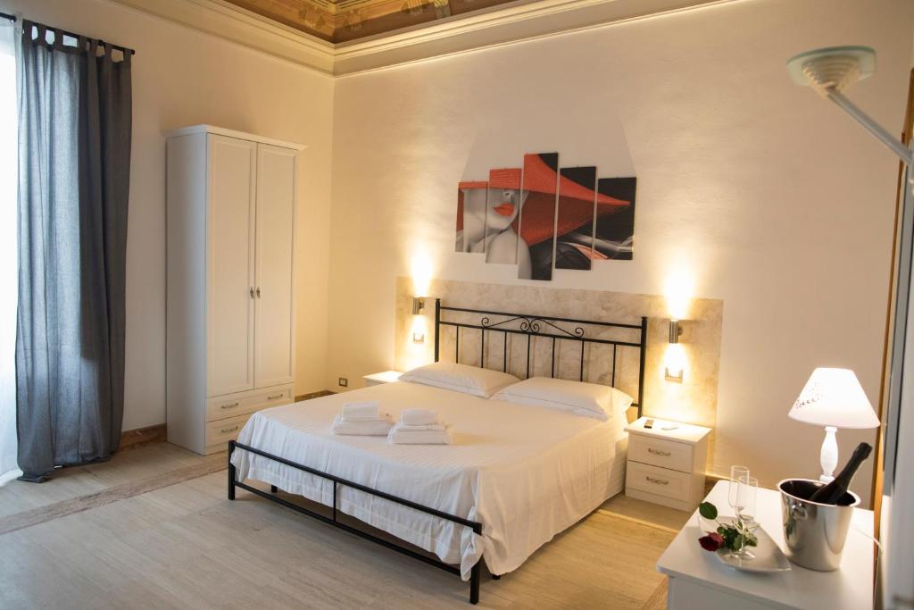 1 dormitorio con 1 cama y una pintura en la pared en B&B Liberty 900, en Catania