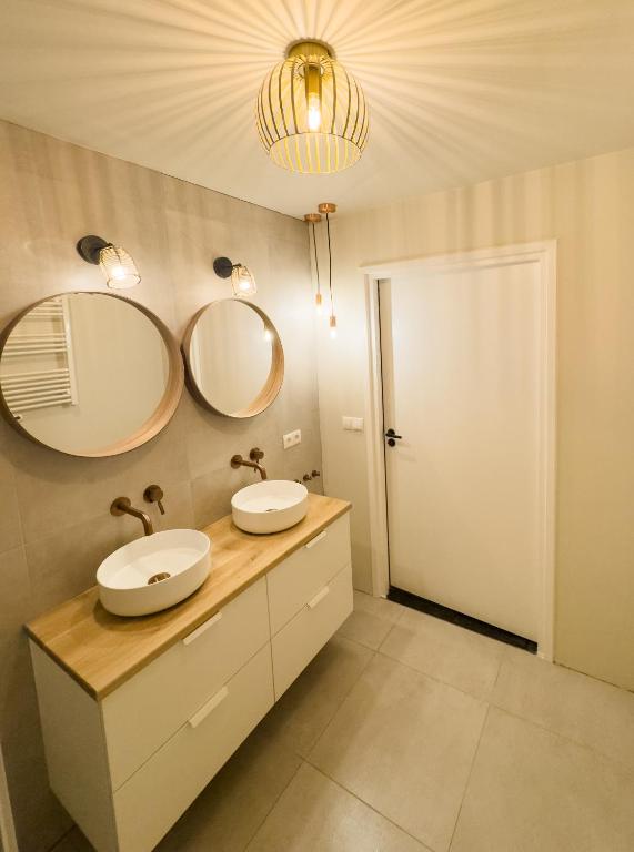 a bathroom with two sinks and two mirrors at luxe stadsappartement Workum in Workum
