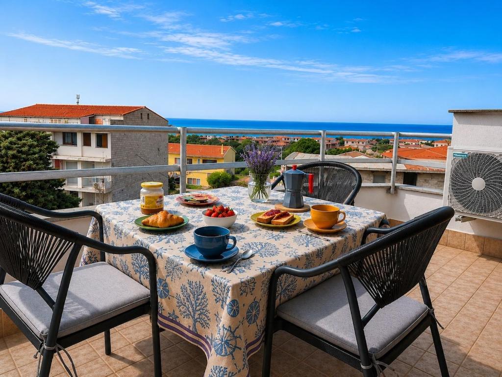 a table with plates of food on a balcony at Luna House - Key to Villas in Valledoria
