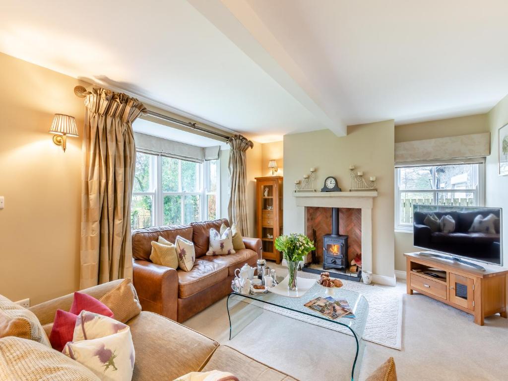 a living room with a couch and a fireplace at Adair Cottage in Wigglesworth