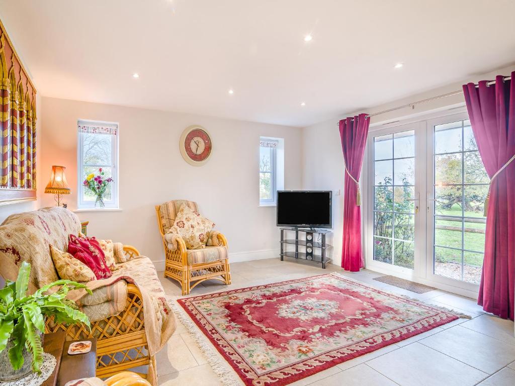 a living room with a couch and a tv at Paddock Barn in North Nibley