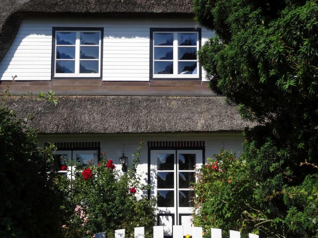 a white house with windows and a white fence at Luckow Georg Asmussen Haus in Pommerby