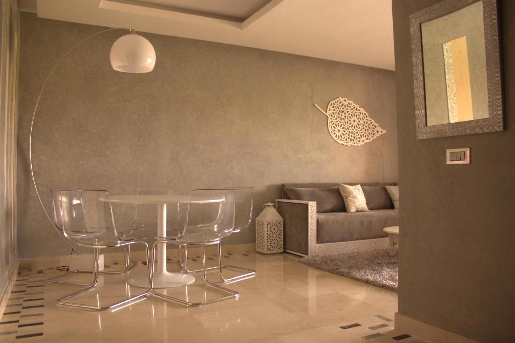 マラケシュにあるPrestigia Golf City Apartmentのリビングルーム(テーブル、ソファ付)