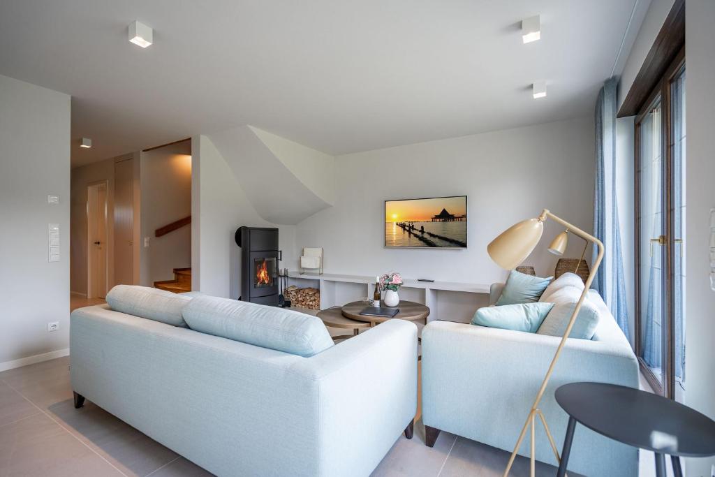 a living room with two white couches and a table at Ferienhaus Reet & Meer N 1 in Bansin